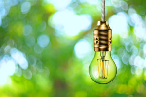 Ledlamp met groene achtergrond als aanmoediging om te verduurzamen tijdens verbouwing